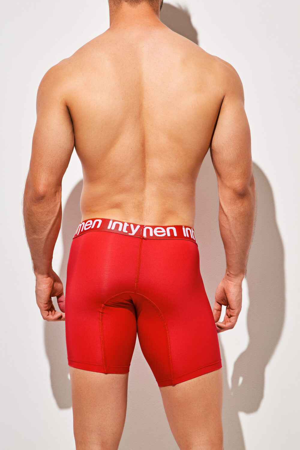 Back view of man wearing red Intymen long boxer briefs with bold logo waistband.