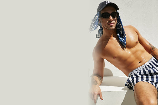 4 Occasions best for Printed Underwear - Muscular man in striped swim shorts, cap, and sunglasses
