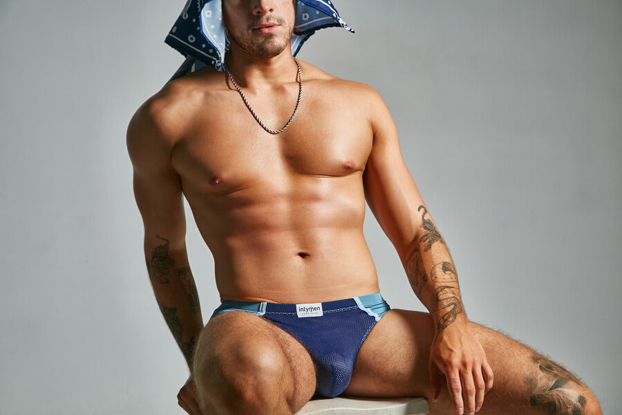 Exploiting the market with Columbus Day in a positive way - Muscular man in blue briefs and a bandana head covering 