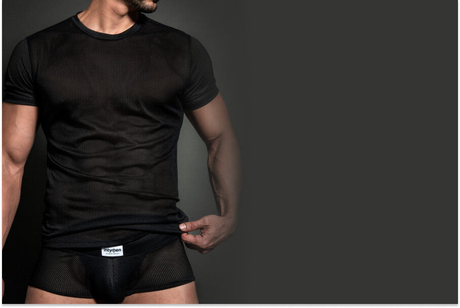 Jockstrap Underwear By Intymen - What Options Do You Have? - Man wearing a black mesh shirt and mesh underwear against a dark background.