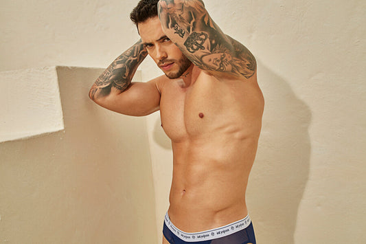 Rock the Tan Spruce Up the Bikini season - Muscular, tattooed man posing shirtless in underwear.