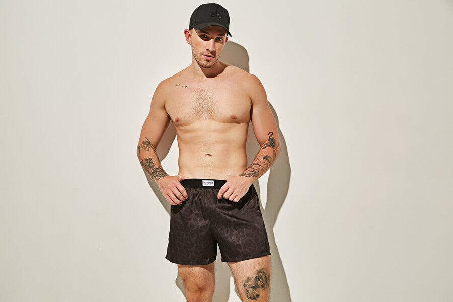 Take a Gander at Men’s Mesh Underwear - Shirtless man in black patterned boxer shorts and a cap. 