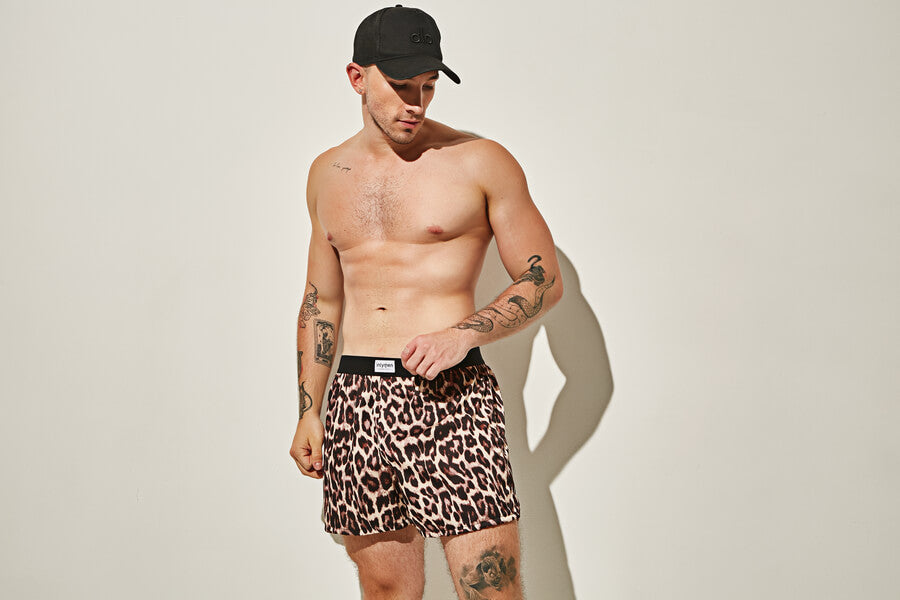 Why not wear something revealing like the men’s mesh underwear - Man posing in leopard-print boxers and a black cap.